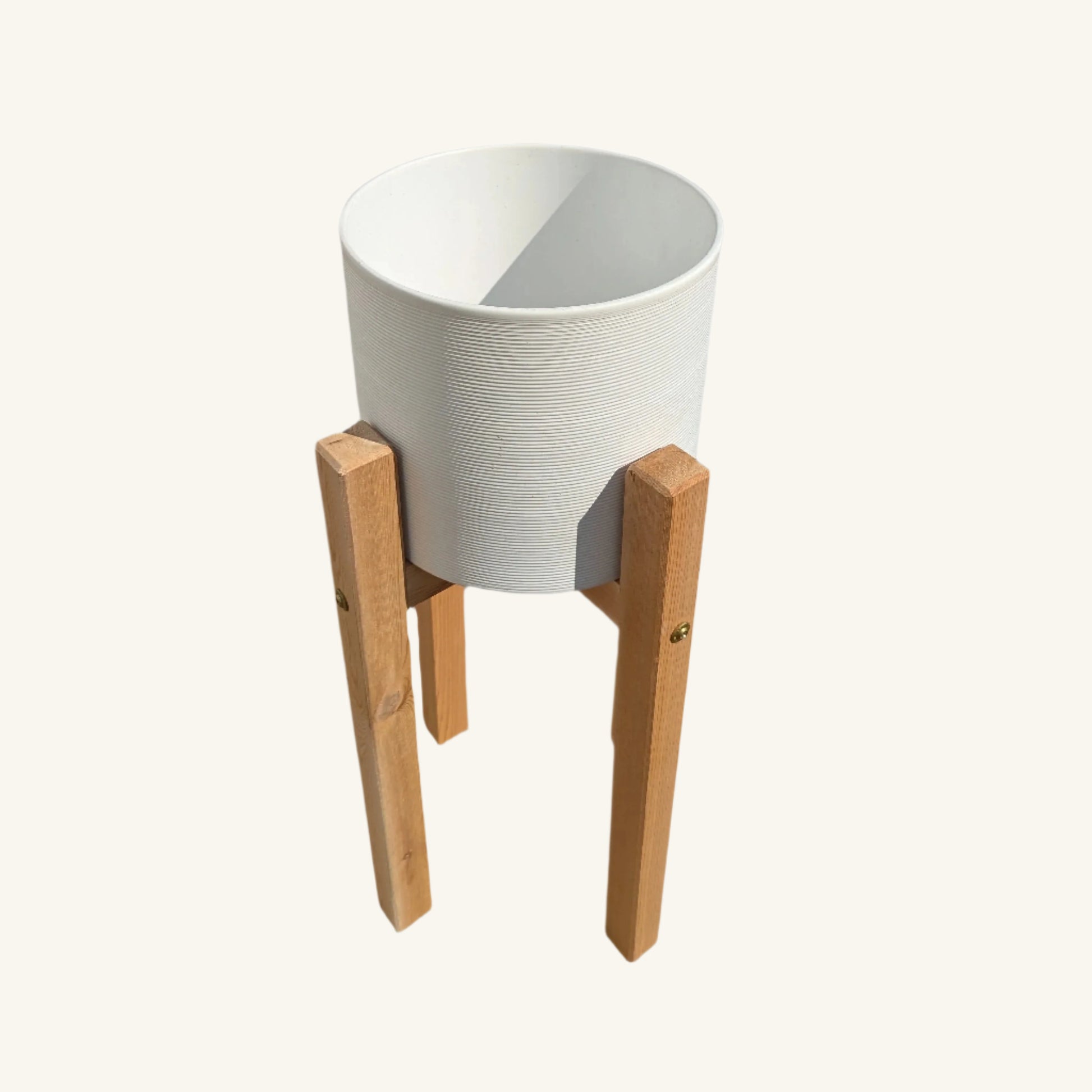 Angled view of small cedar and ceramic planter stand, combining rustic cedar warmth with a modern ceramic silhouette.
